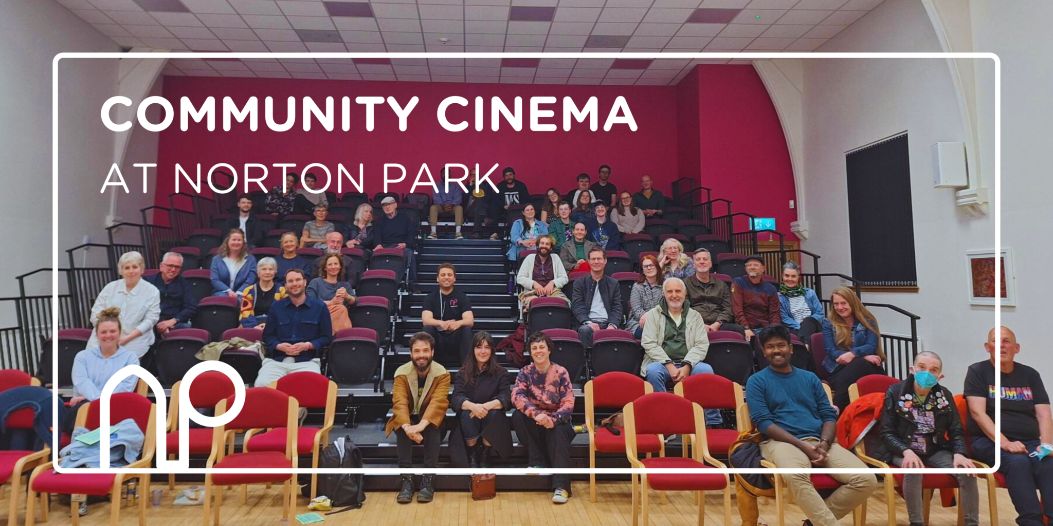 Tiered seating in Norton Park's conference hall, full of viewers ready for a community film screening
